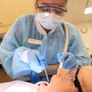 A female dental assistent cleaning teeth