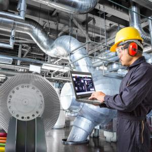 Man working on equipment with a laptop